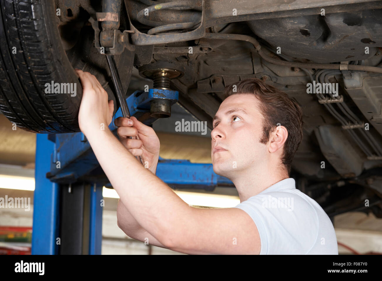 Mechanic Working On Wheel Underneath Car Stock Photo Alamy