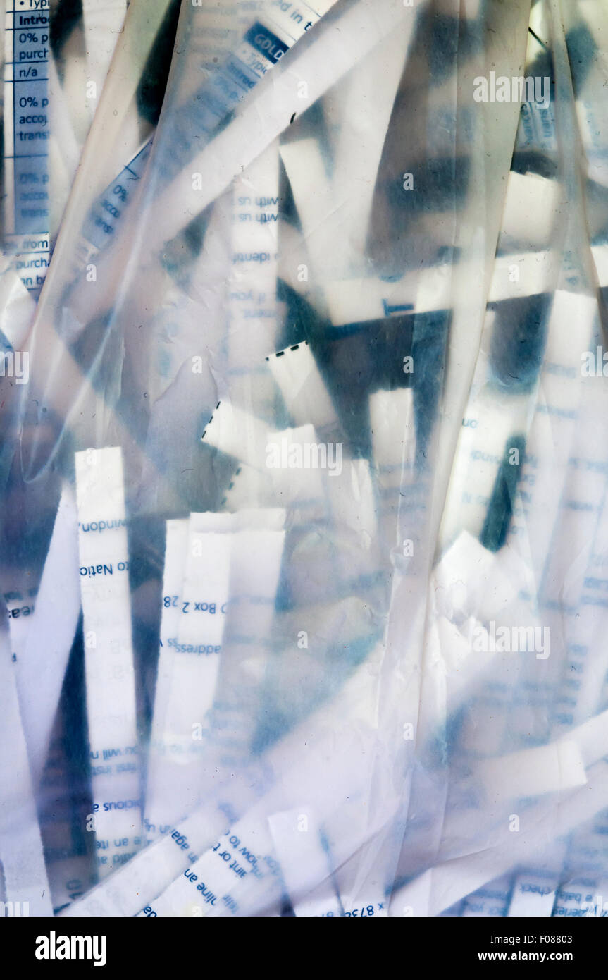 Securely shredded paper seen through the side of a transparent plastic bag. Stock Photo