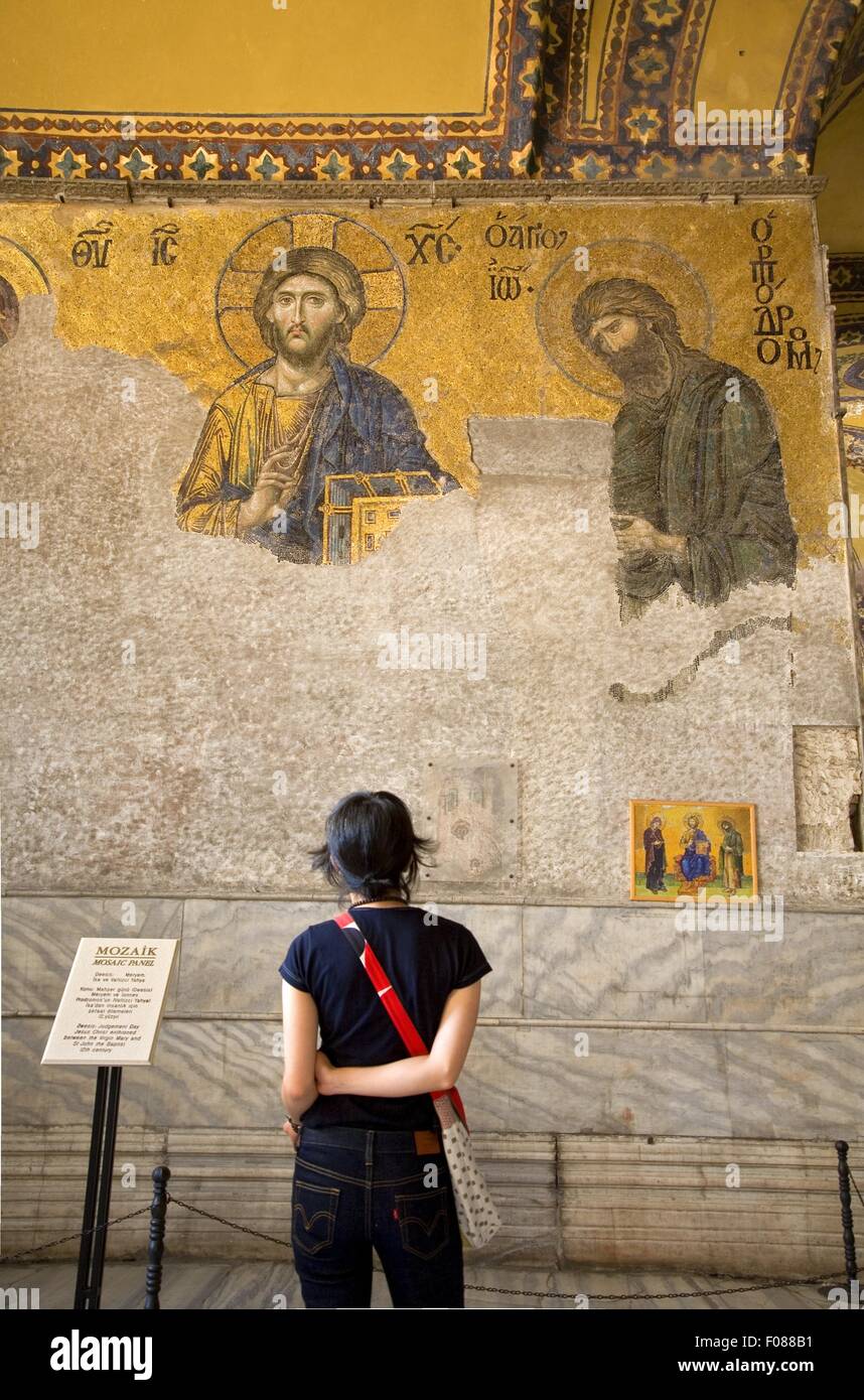 Rear view of woman looking at mosaic of Jesus on wall in Hagia Sophia, Istanbul, Turkey Stock Photo