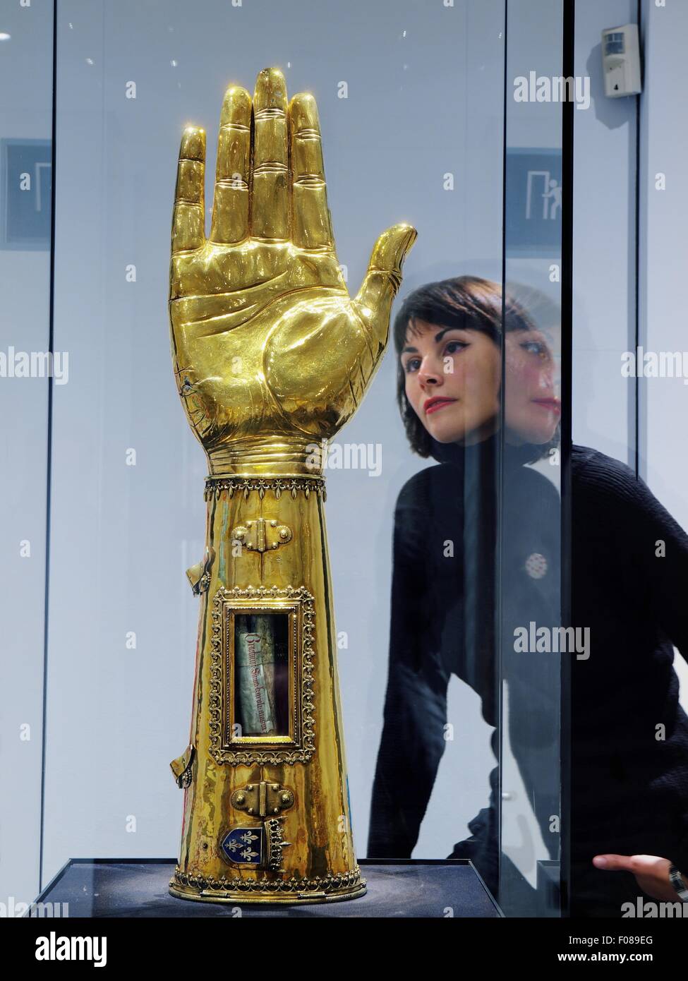 Women looking at arm kept in reliquary in glass box at the Cathedral Treasury, Germany Stock Photo