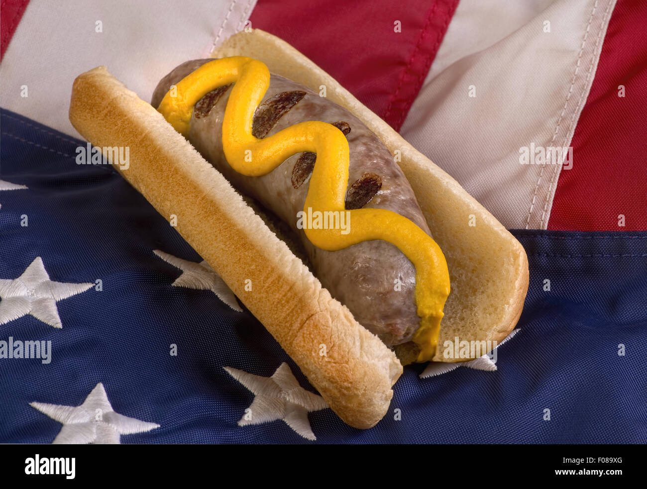 Grilled bratwurst on bun and American flag. Stock Photo