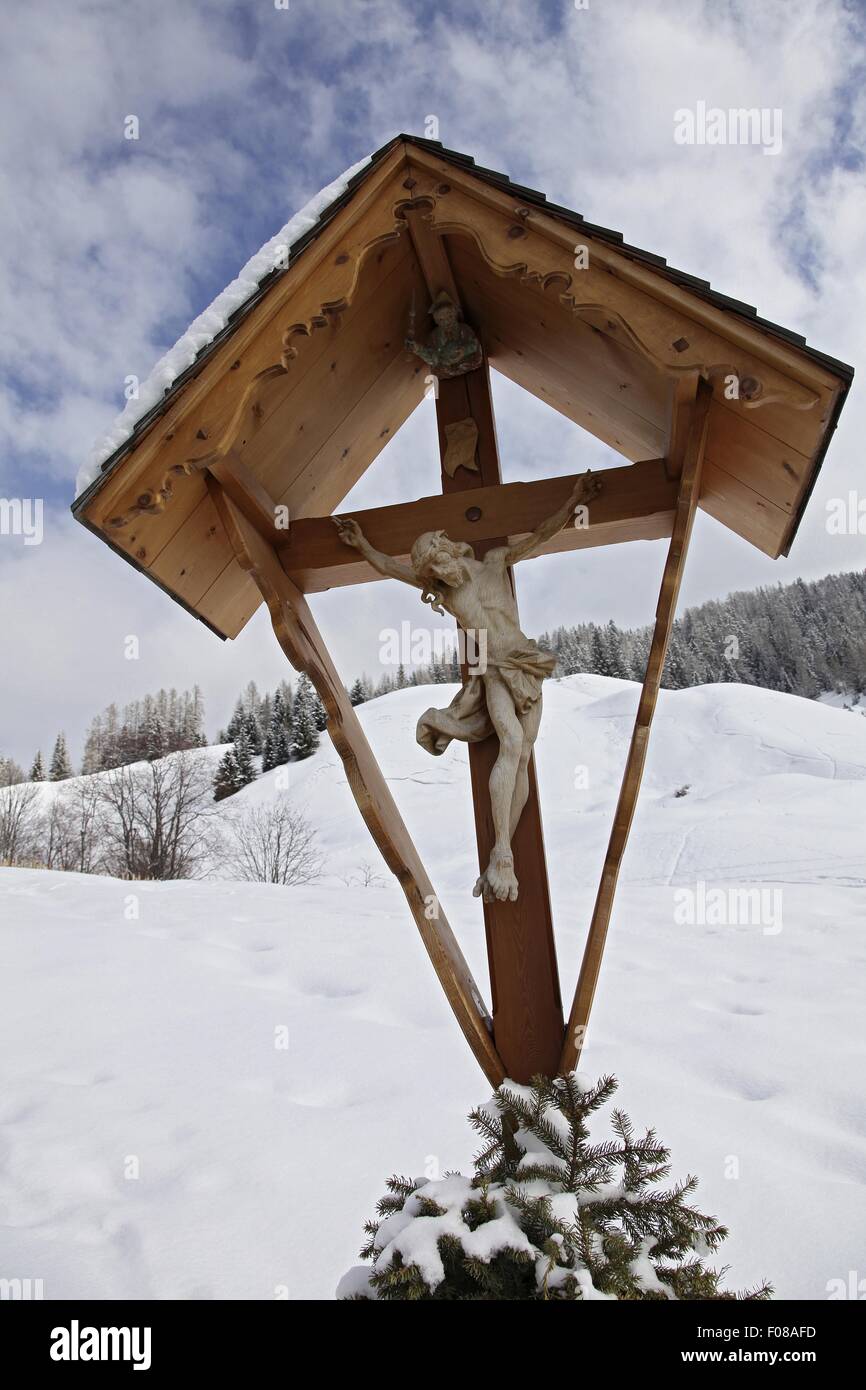 Close-up of shrine with crucifix in snow, South Tyrol, Italy Stock Photo