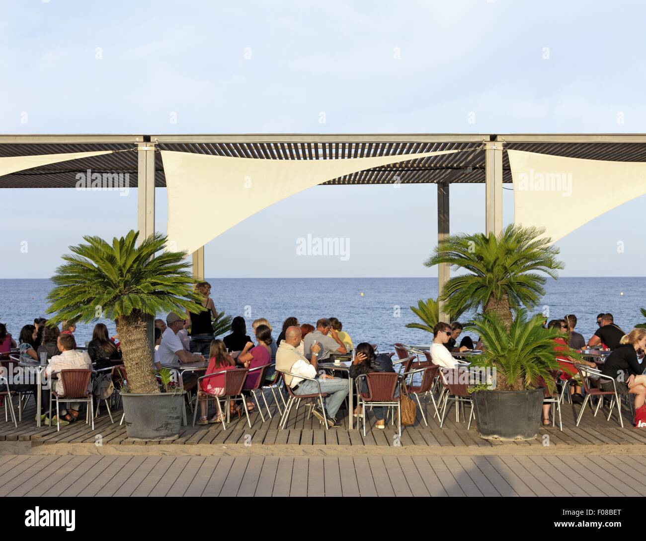 Guests at Barcelona beach restaurant overlooking sea in Barcelona