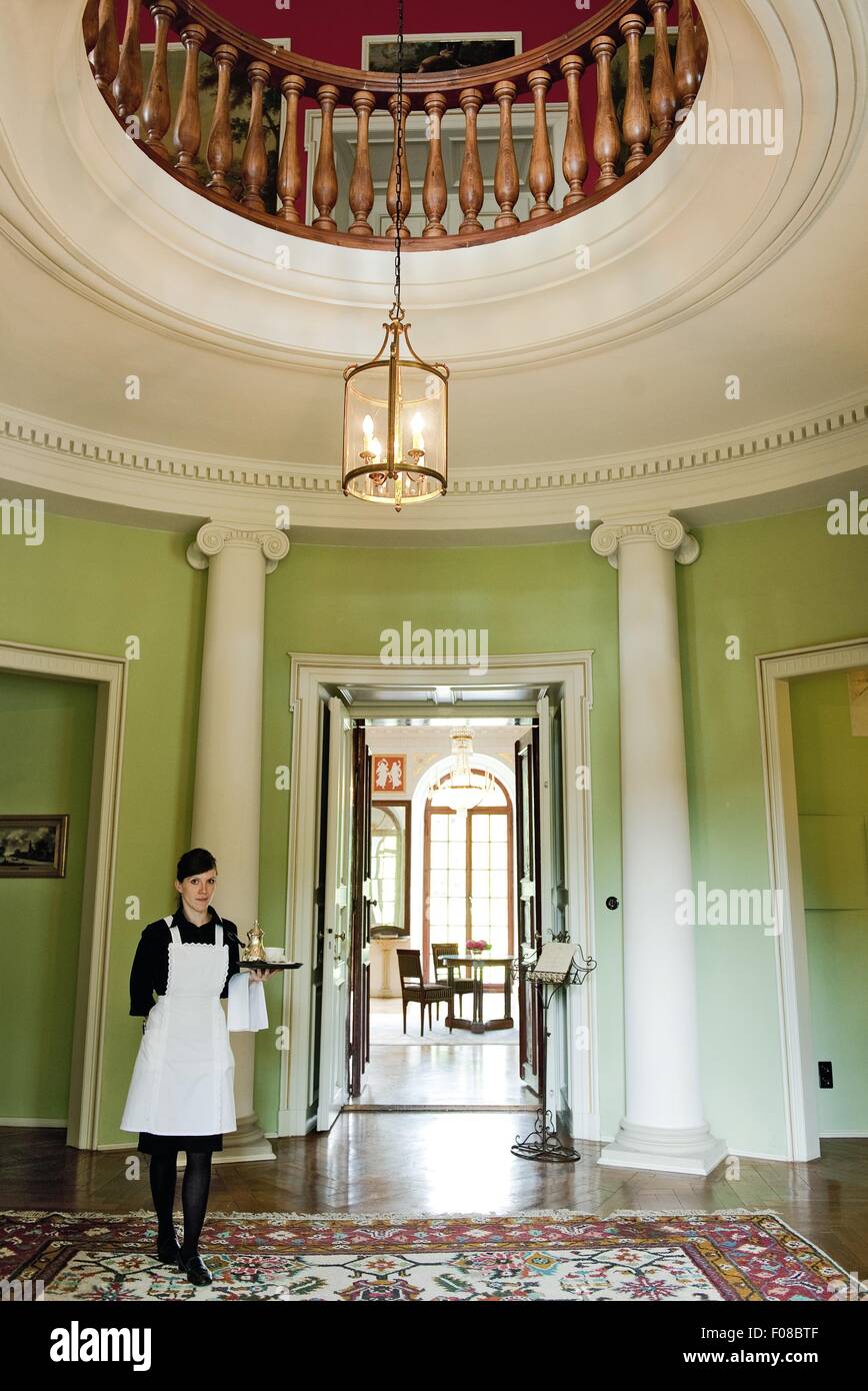 View of maid standing in front of Castle Gaussig door, Saxony, Germany Stock Photo
