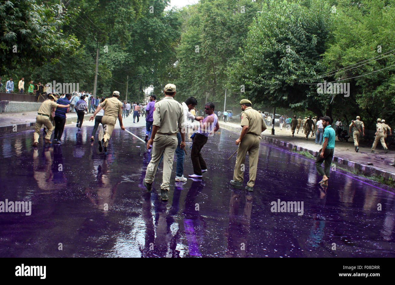 Srinagar, Indian Administered Kashmir. 10th Aug, 2015.Indian policeman baton-charges to disperse protesting Kashmiri government employees. Police detained dozens of government employees who were protesting and demanding regularization of contractual jobs and a hike in salary Credit:  Sofi Suhail/Alamy Live News Stock Photo