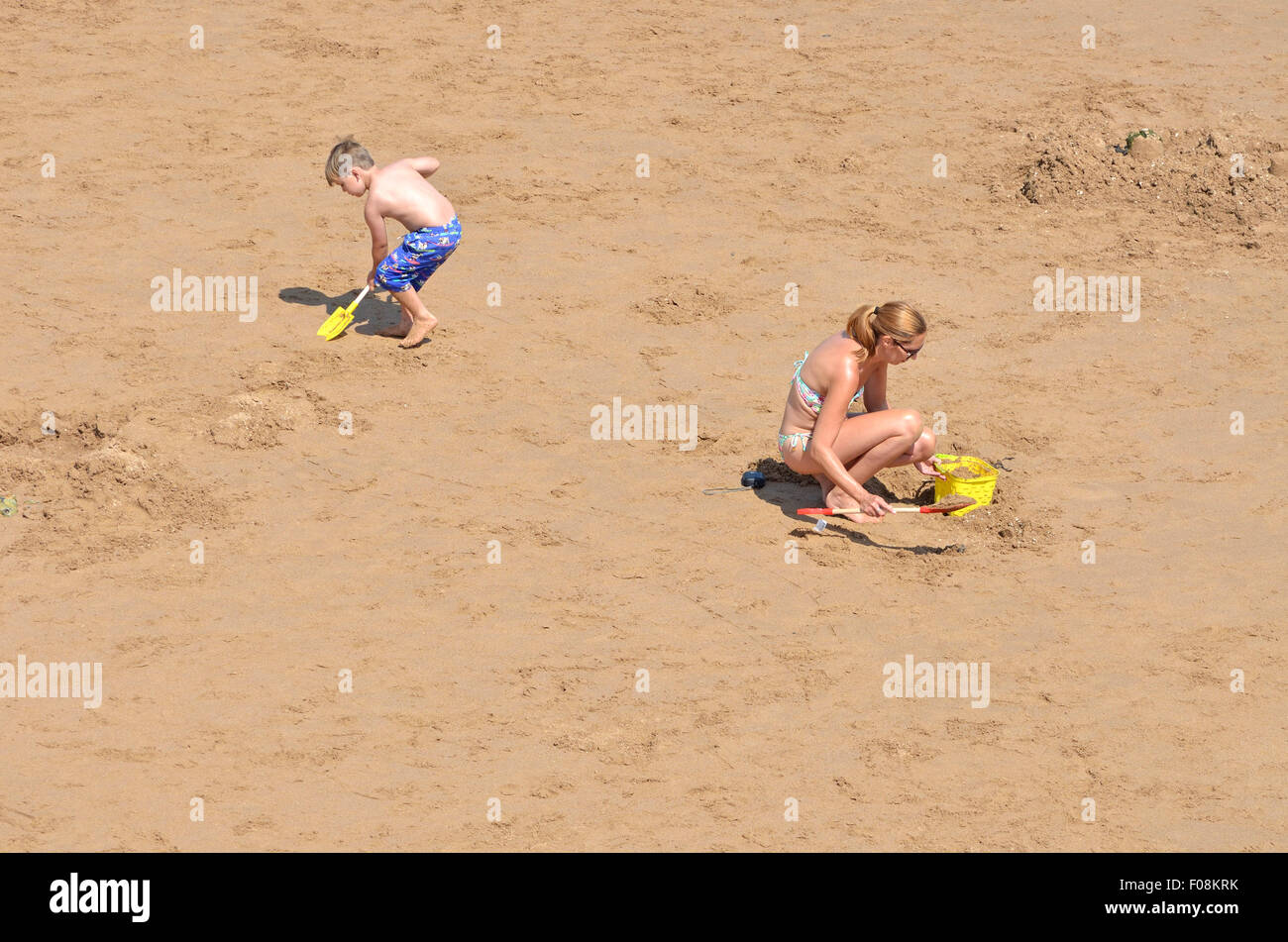 Broadstairs, Kent, England, UK. Viking Bay beach. Mother and son digging in the sand Stock Photo