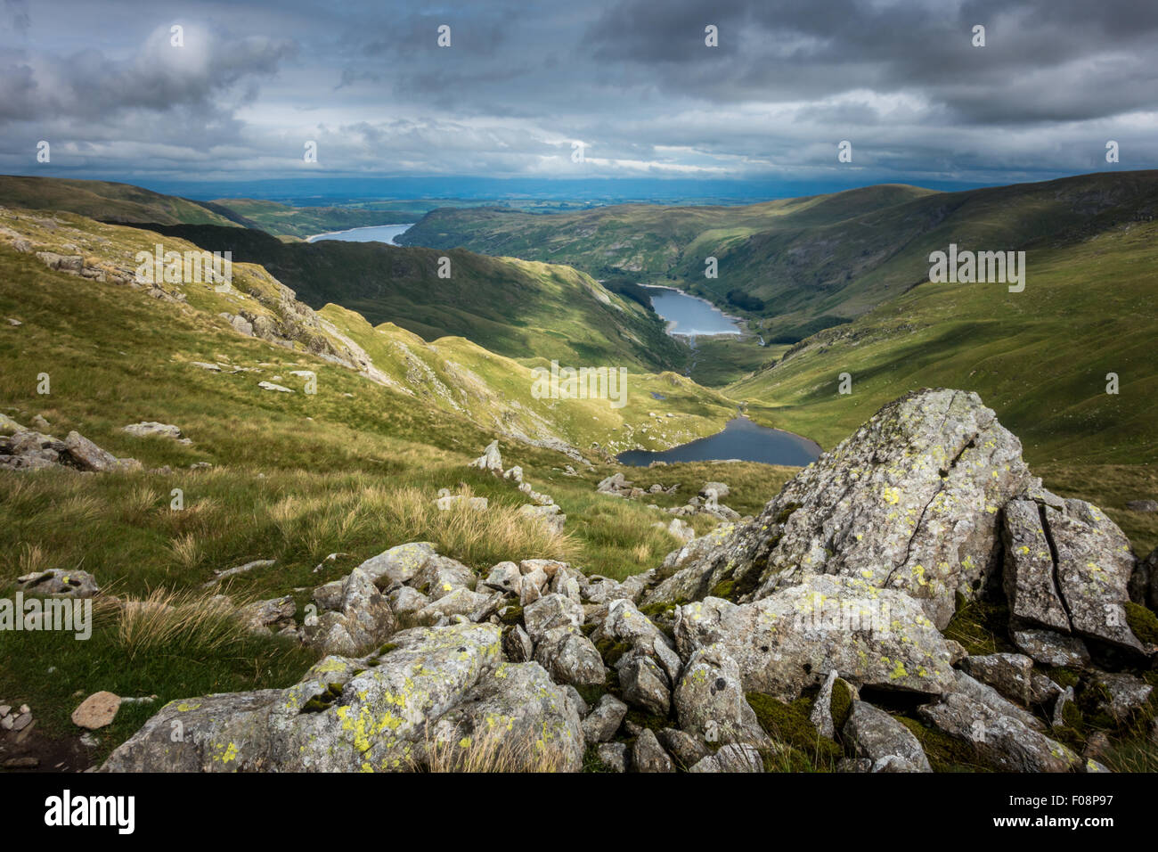 Standing at the head of the Kentmere horseshoe, English Lake District looking down at Kentmere Reservoir and Haweswater behind. Stock Photo