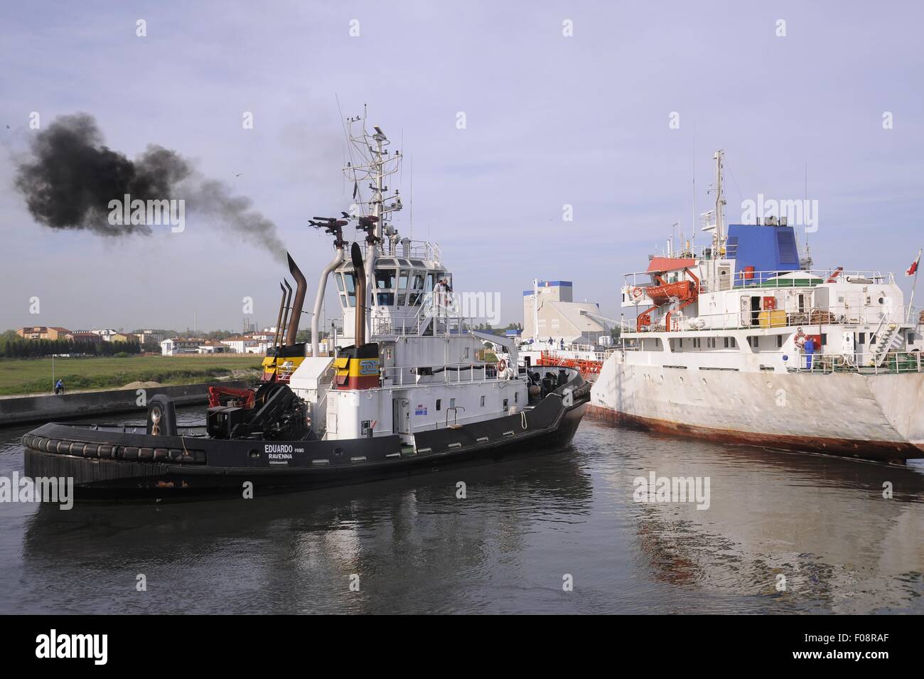 port of Ravenna (Italy), merchant ship and tug maneuvering Stock Photo