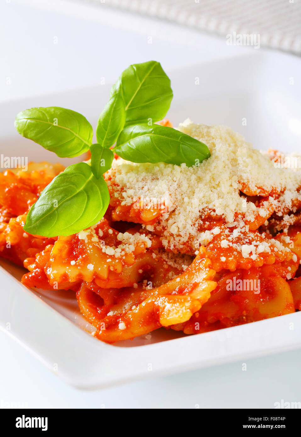 Bow-tie pasta with tomato sauce and parmesan Stock Photo - Alamy