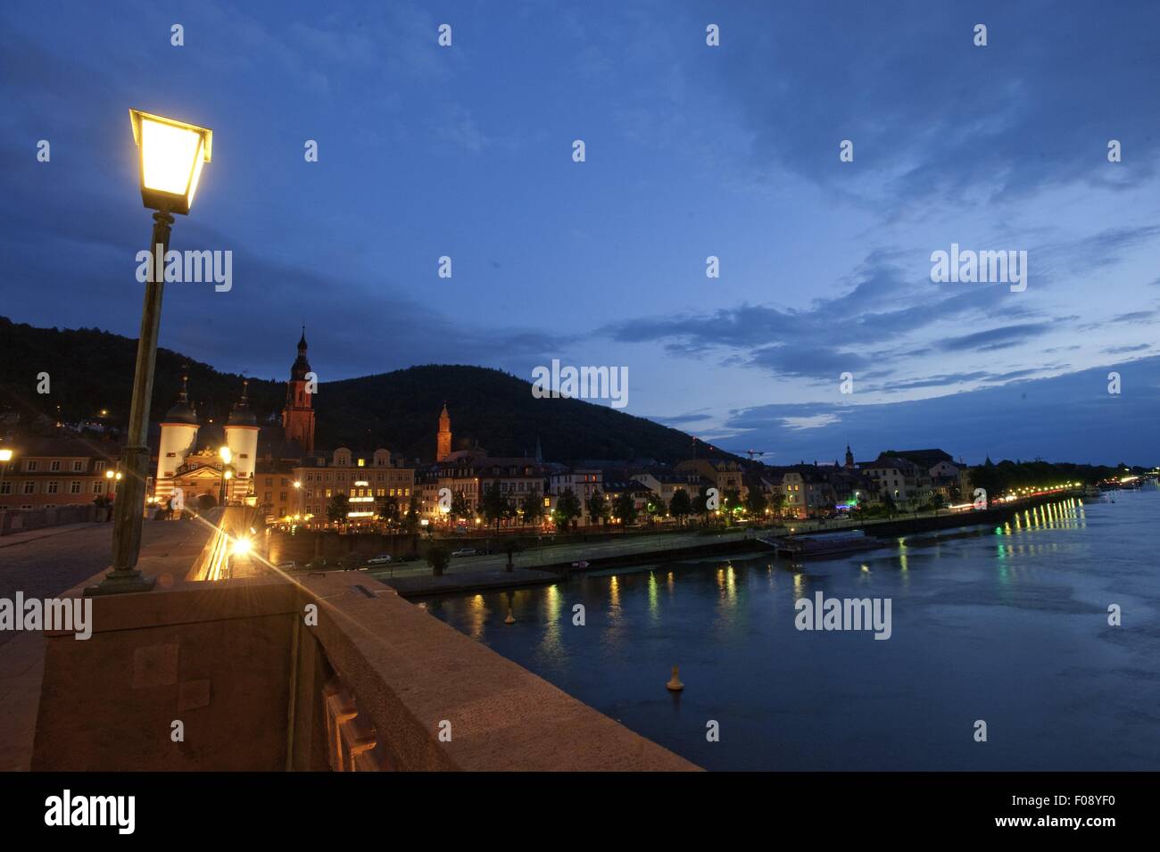 Illuminated Karl Theodor Bridge overlooking river Neckar at night in Heidelberg, Germany Stock Photo