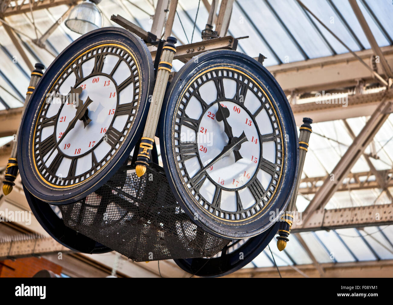 Large decorative clock hanging from a train station roof Stock Photo