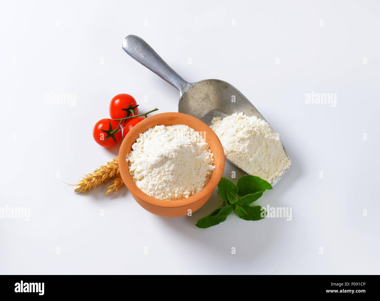 Finely ground flour in terracotta bowl and metal scoop Stock Photo