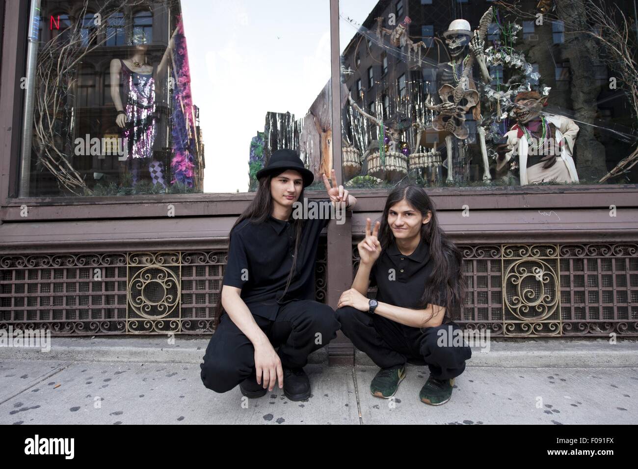 Women crouching in front of Fantasy and Carnival Store in SoHo, New York, USA Stock Photo