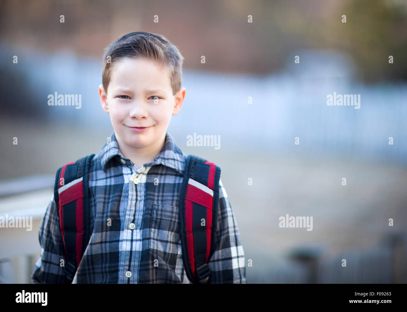 Handsome young boy with a backpack outside Stock Photo