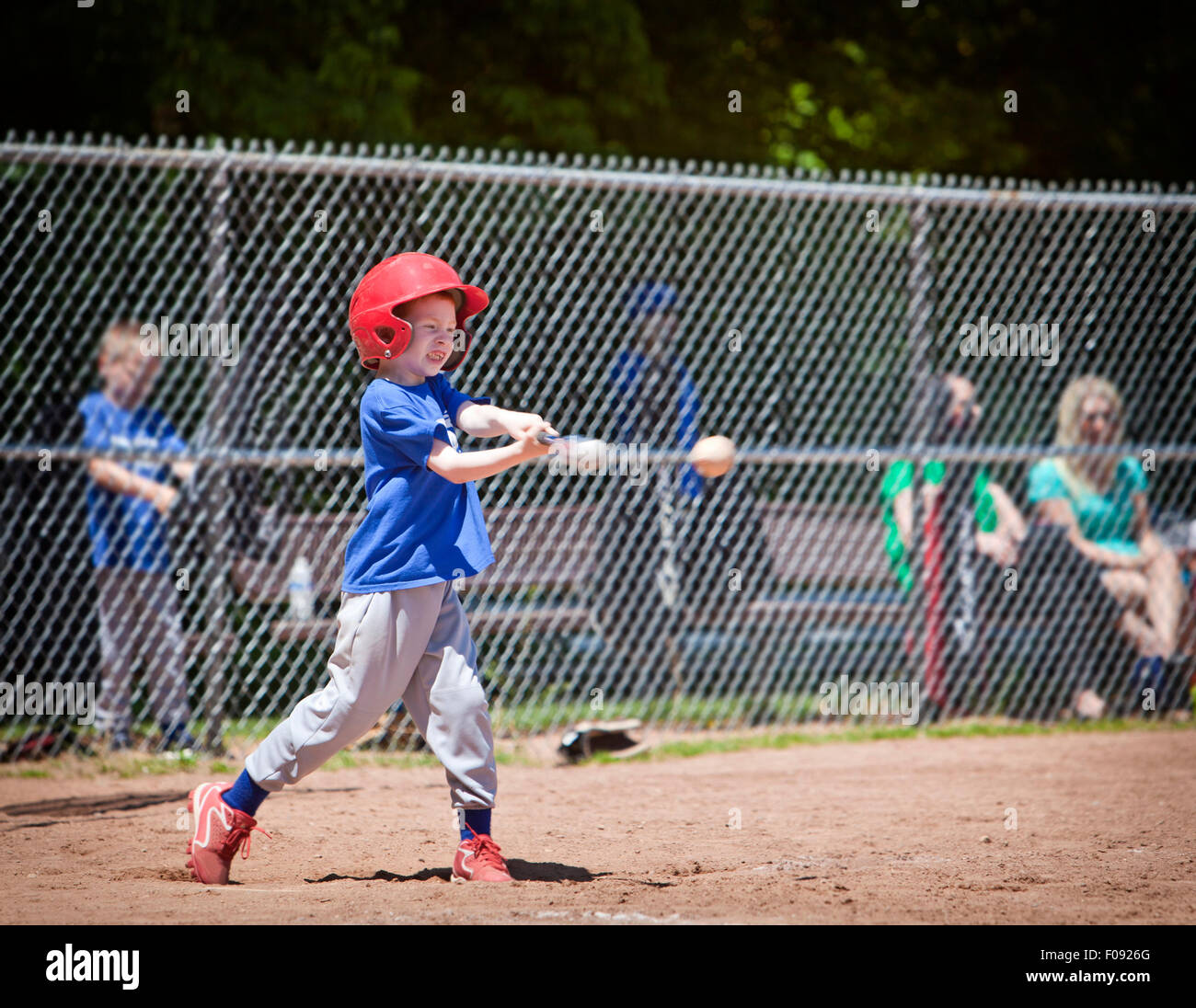 A youth baseball player takes a nice swing at the ball Stock Photo