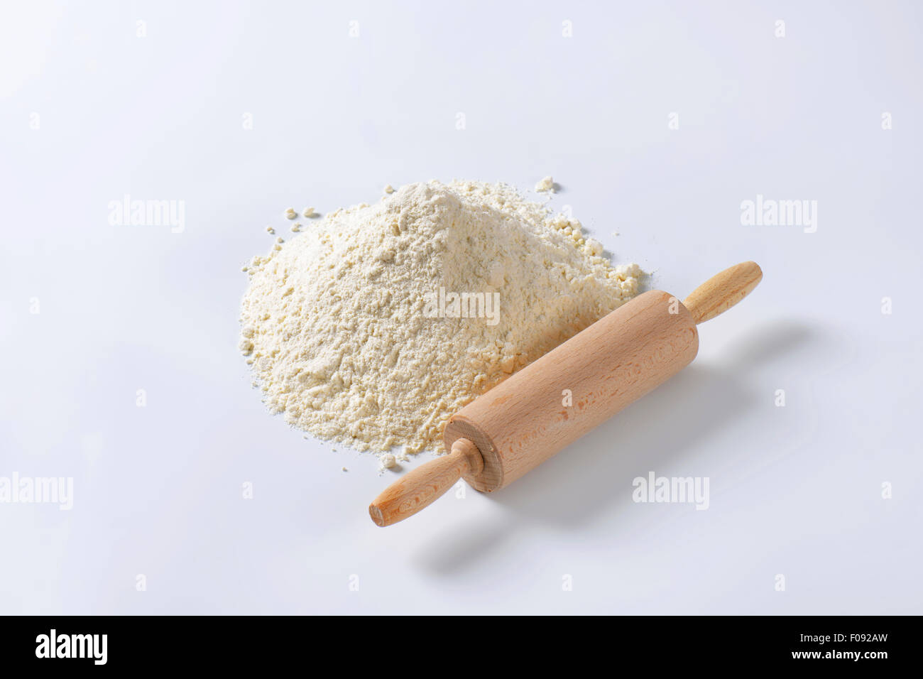 Wooden 'roller' type rolling pin and pile of finely ground flour Stock Photo
