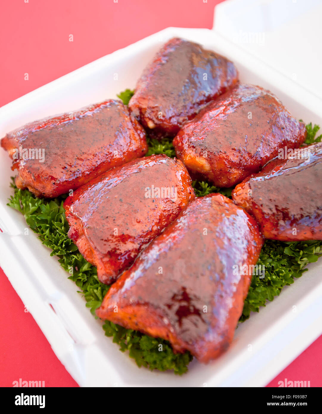 BBQ chicken thighs on a bed of parsley Stock Photo