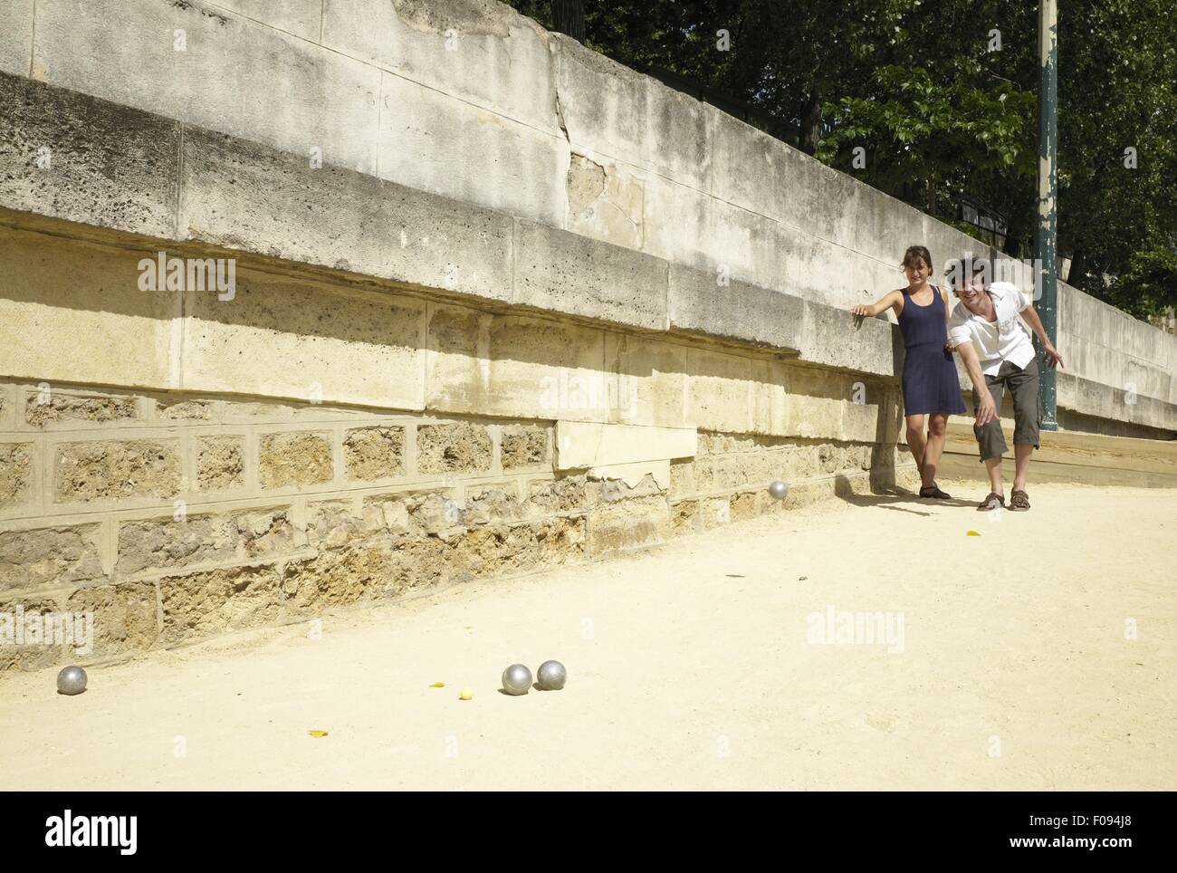 Couple playing bocce ball on bank of Seine River, Paris, France Stock Photo