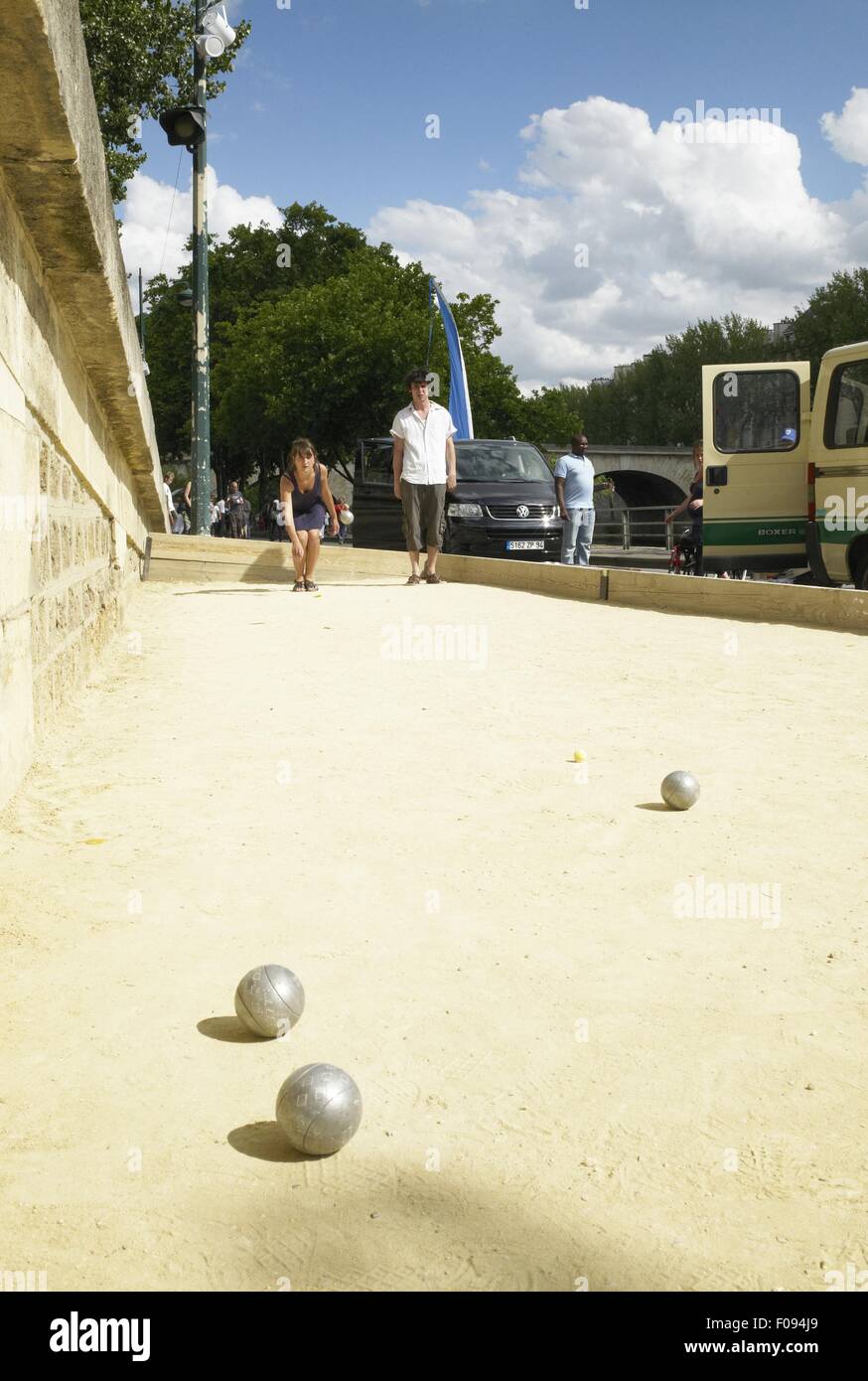 Couple playing bocce ball on bank of Seine River, Paris, France Stock Photo