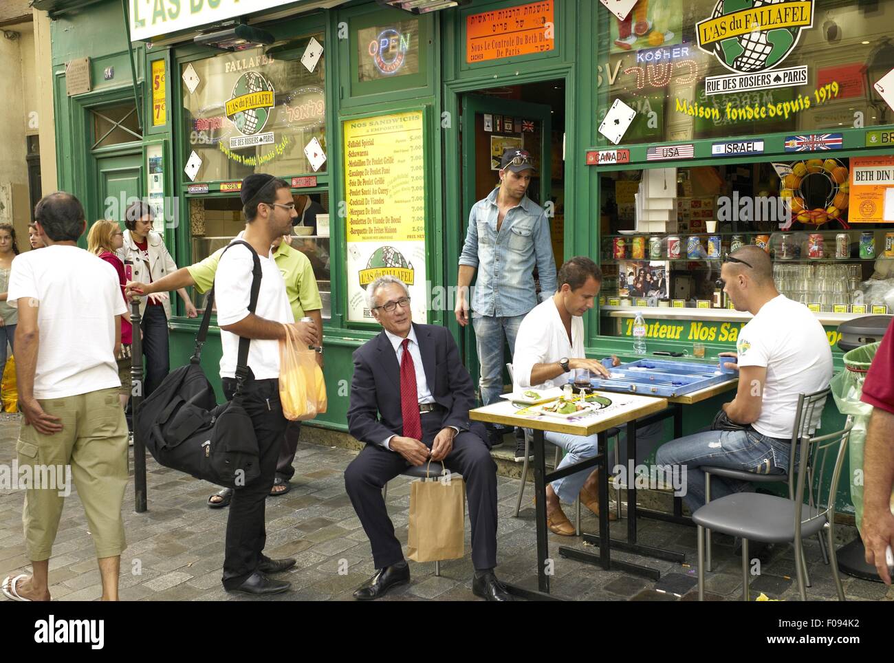 People sitting on chairs in front of restaurant in Marais, Paris, France Stock Photo