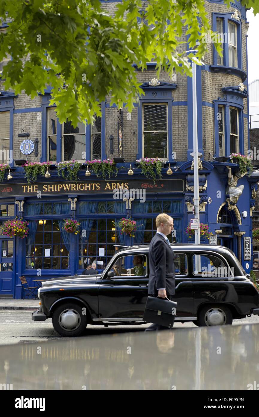 Side view of businessman in front of Black taxi cab, London Borough of Southwark, UK Stock Photo