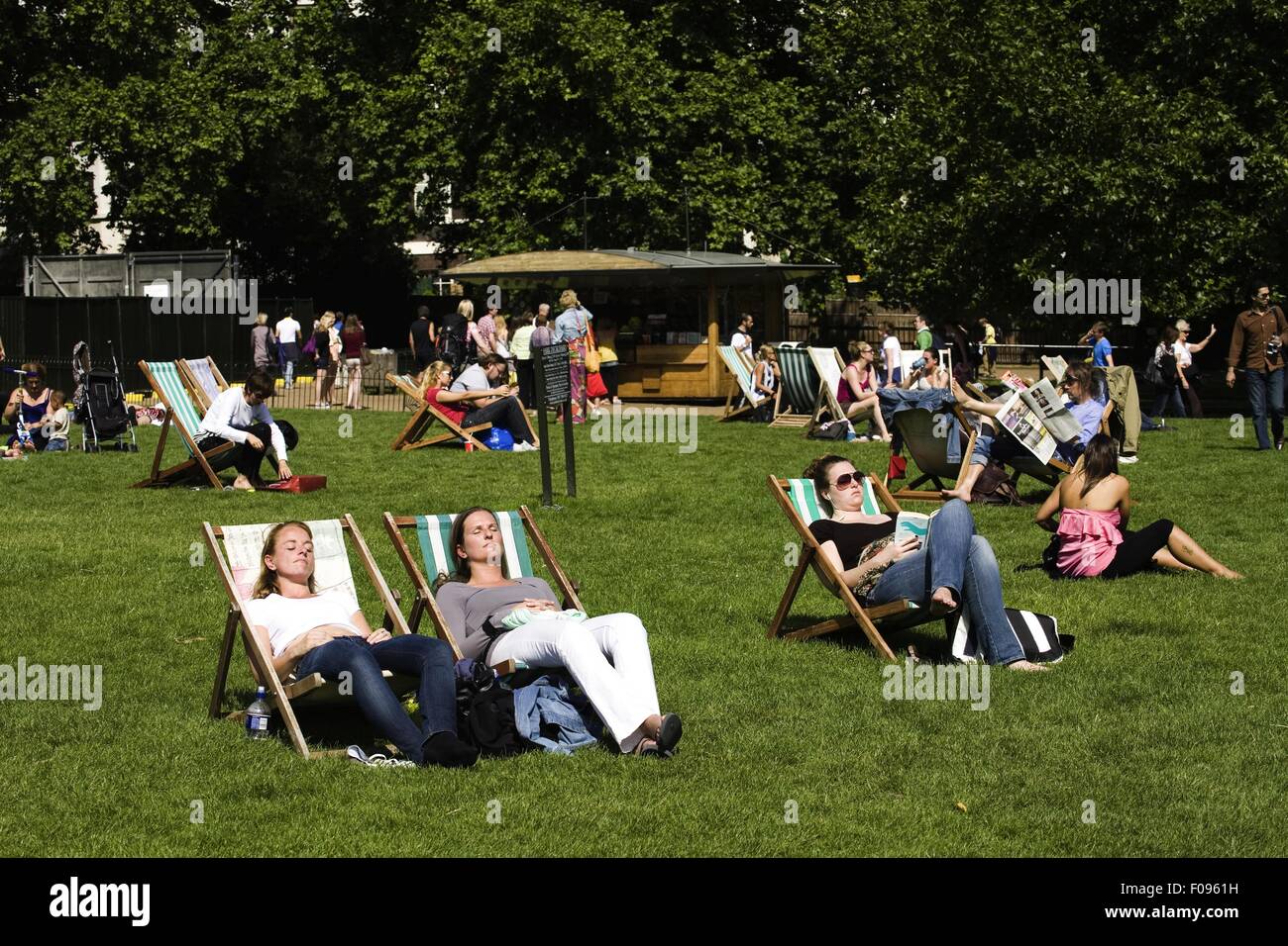 People relaxing in deckchairs in Green Park, Westminster, London, UK