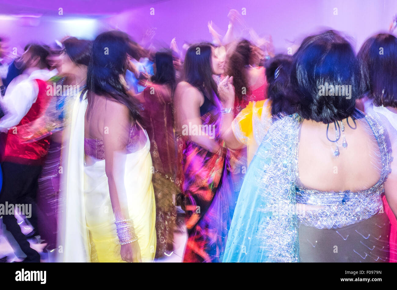 Indian Women in Colourful Saris Dancing at Wedding Reception Stock Photo