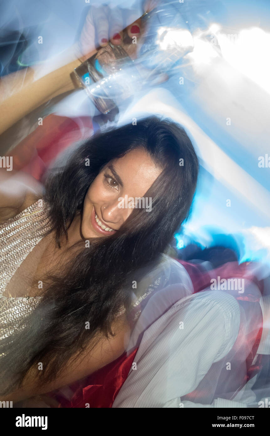 Young Woman Dancing in Club and Holding Drink Stock Photo