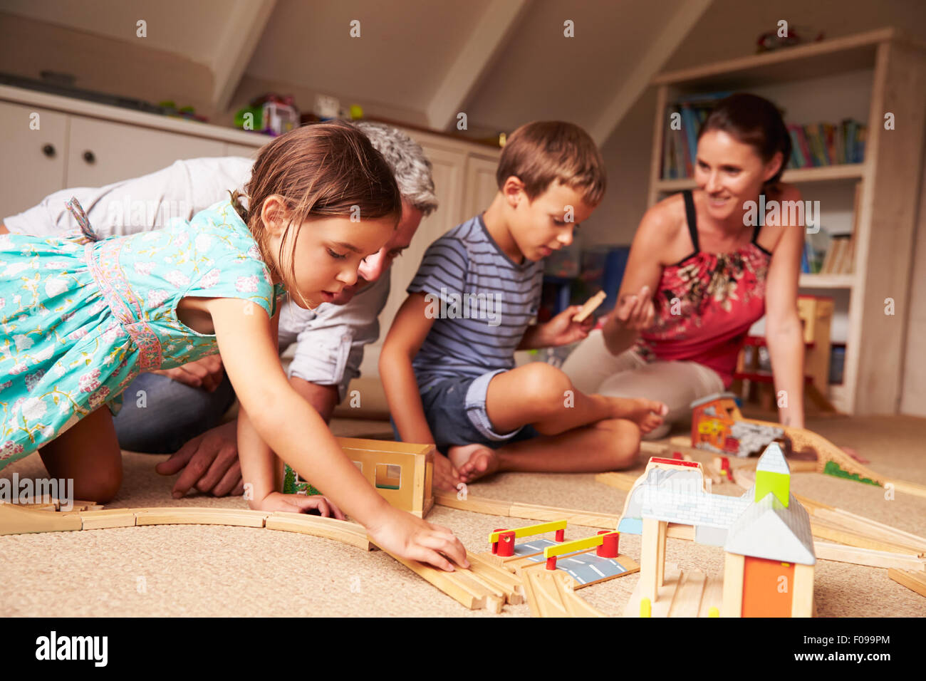 Parents playing with kids and toys in an attic playroom Stock Photo Alamy