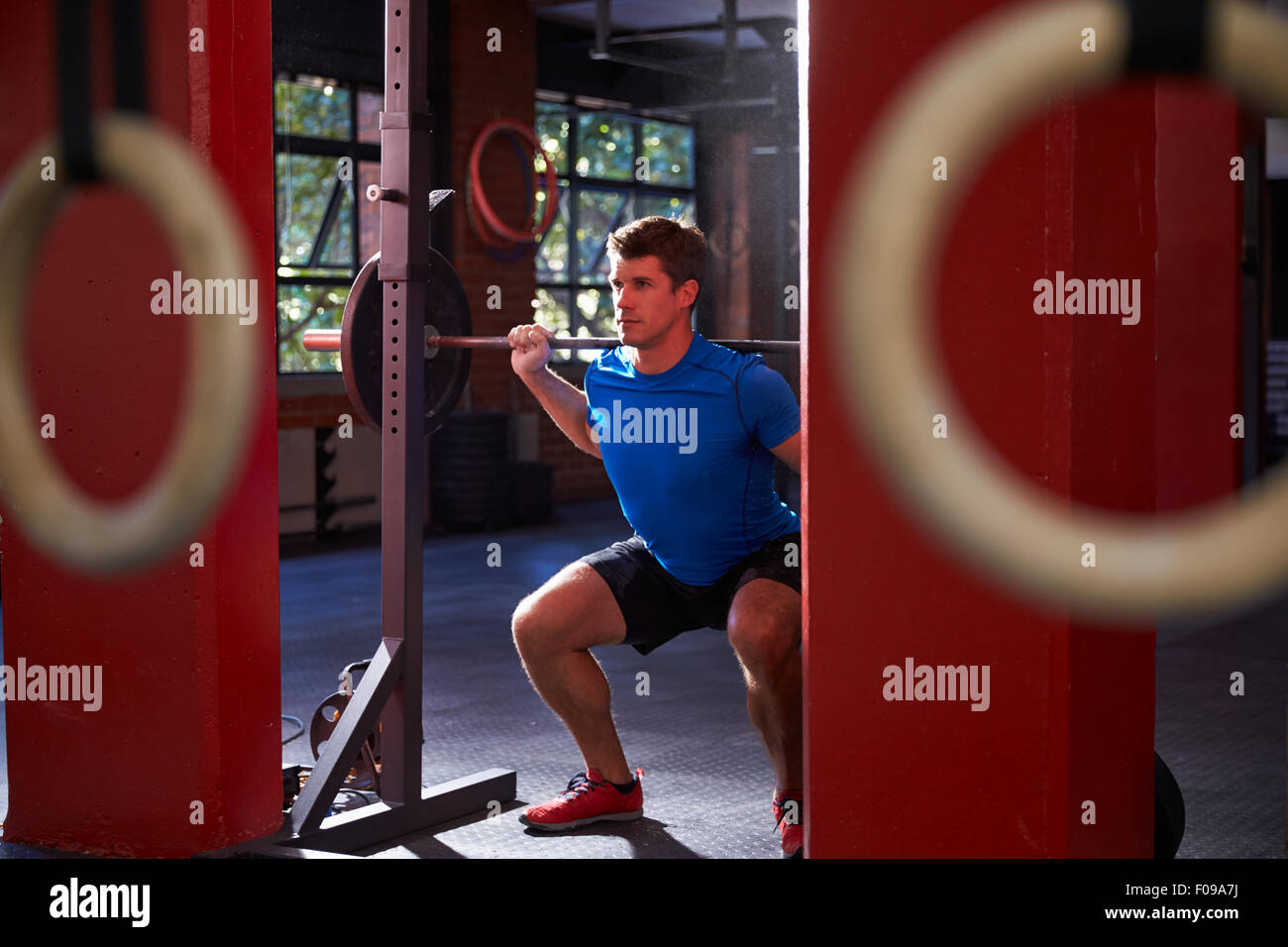 Man In Gym Clean And Jerk Lifting Weights Stock Photo