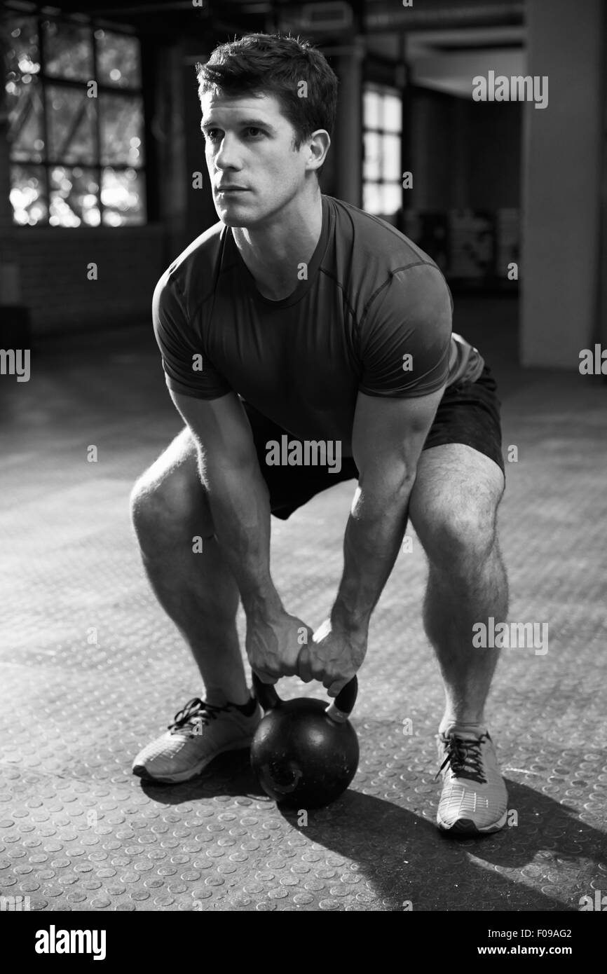 Black And White Shot Of Man Exercising With Kettle Bell Stock Photo