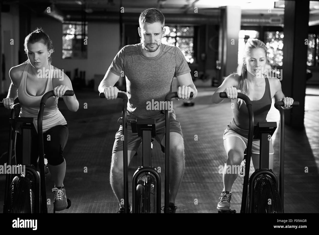 Black And White Shot Of Gym Class Using Cross Trainers Stock Photo