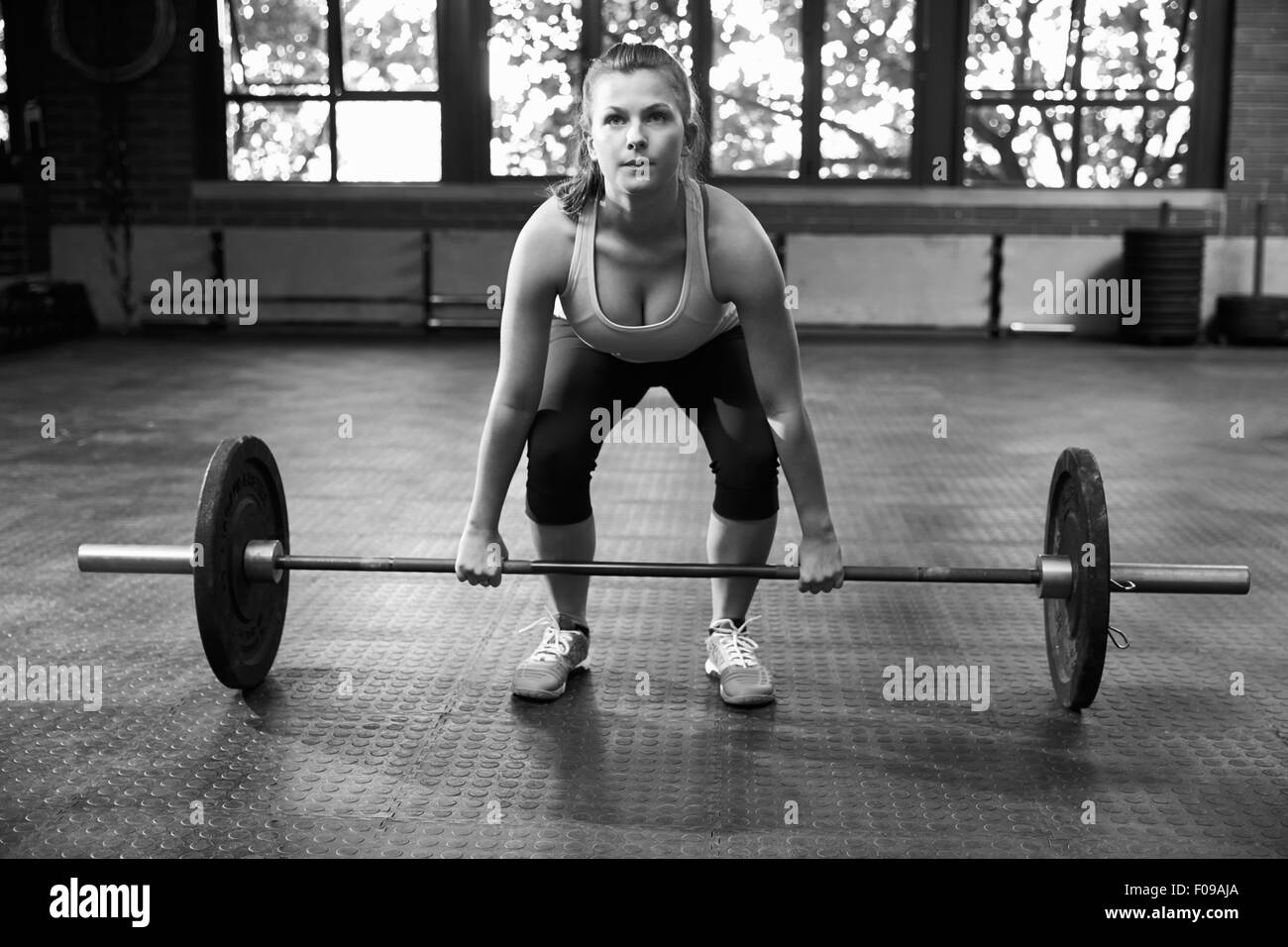 Black And White Shot Of Woman Preparing To Lift Weights Stock Photo