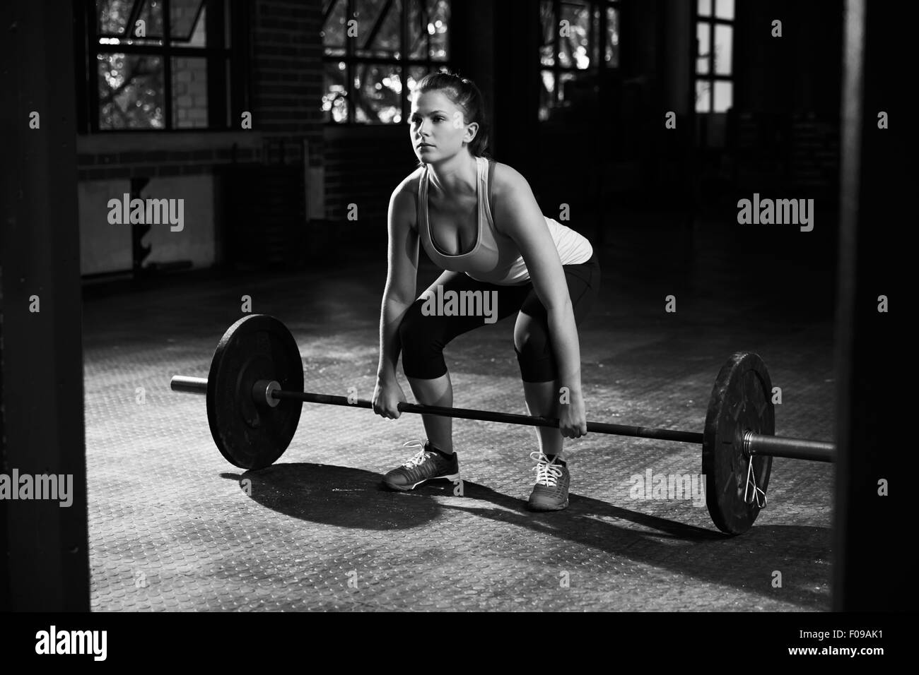 Black And White Shot Of Woman Preparing to Lift Weights Stock Photo