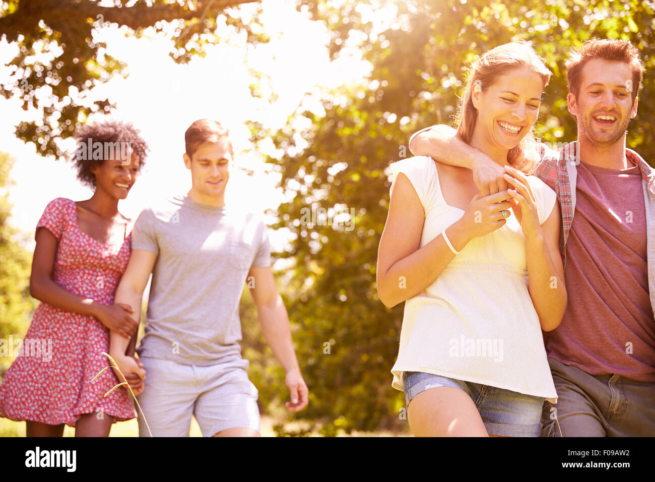 Four friends walking together in the countryside Stock Photo - Alamy