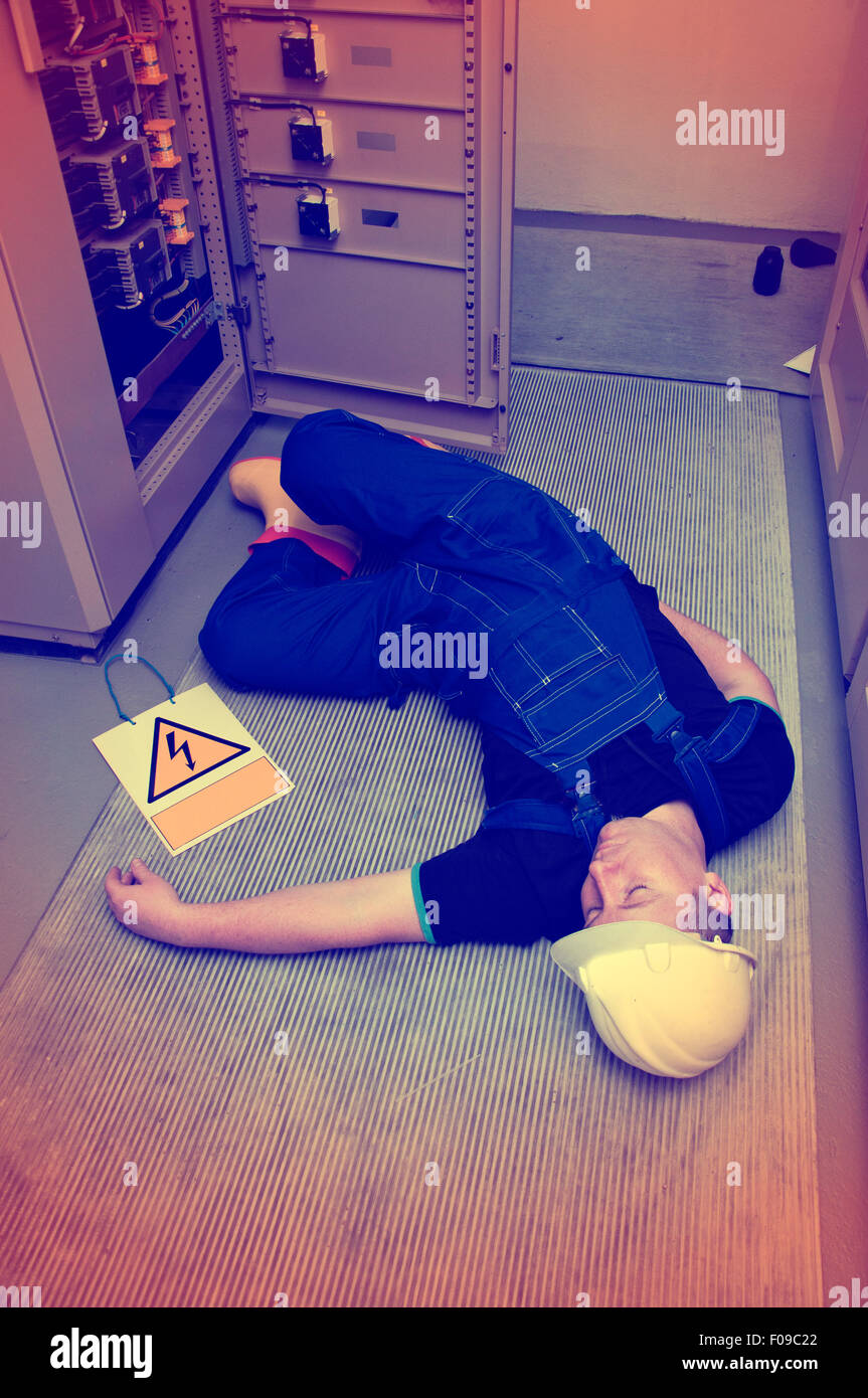 electrician electrocuted - wounded man lying on the ground Stock Photo