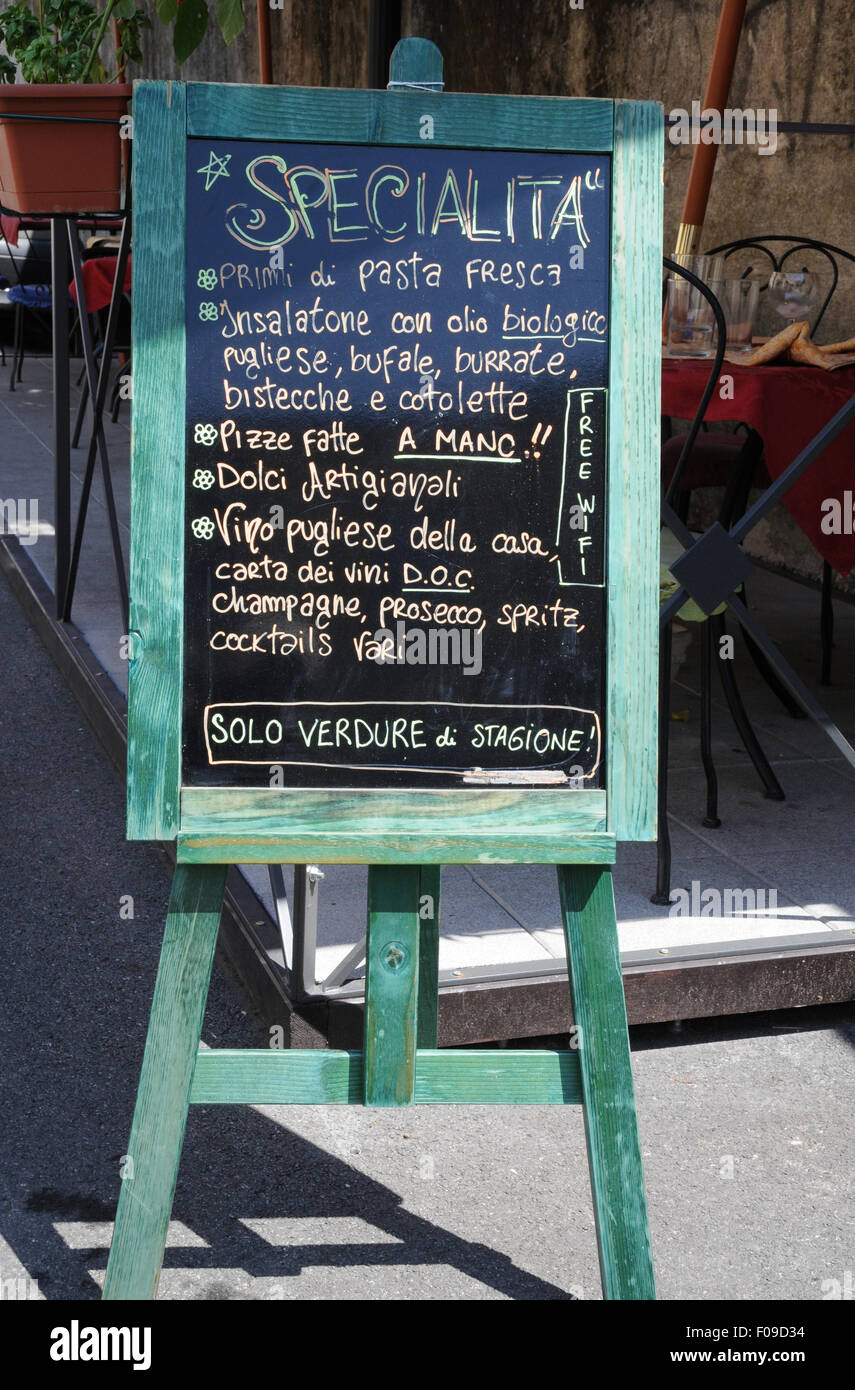 A restaurant chalk board advertising its fare in a street near the Leaning Tower of Pias, an area of the city full of tourists. Stock Photo