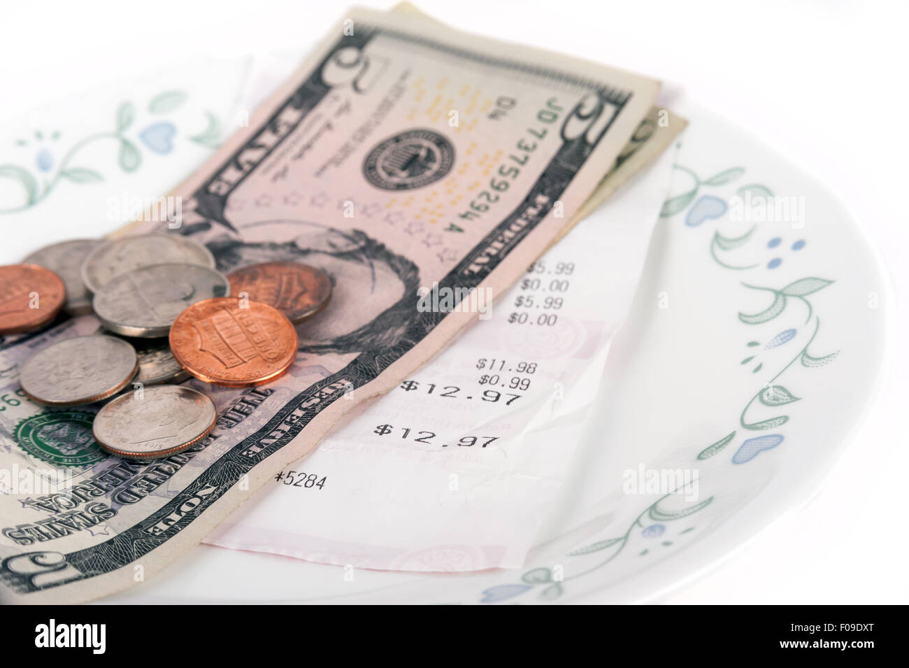 Restaurant bill with dollar bills (tips) on a plate and receipt isolated on a white background Stock Photo