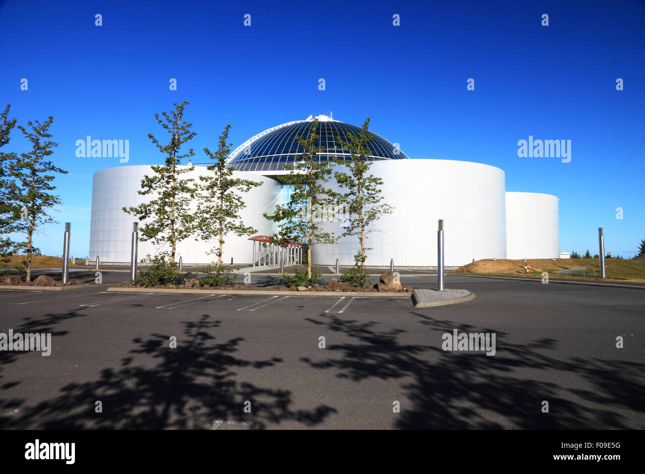 A group of cylindrical metal tanks with flags and deep blue sky. Stock Photo