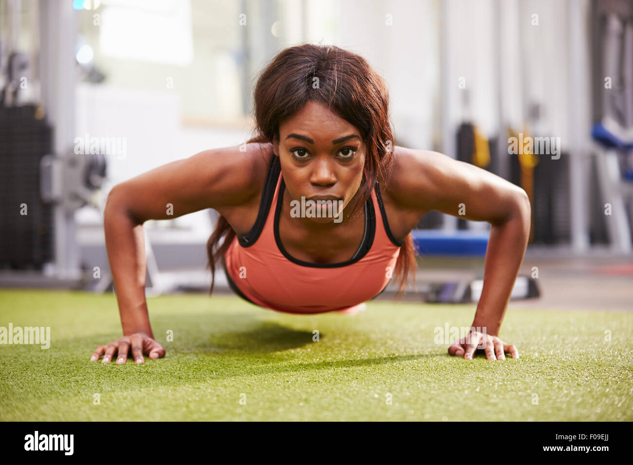 Young woman doing push ups at a gym Stock Photo - Alamy