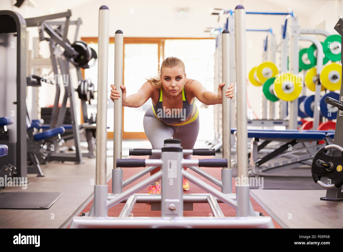 Woman working out using equipment at a gym Stock Photo