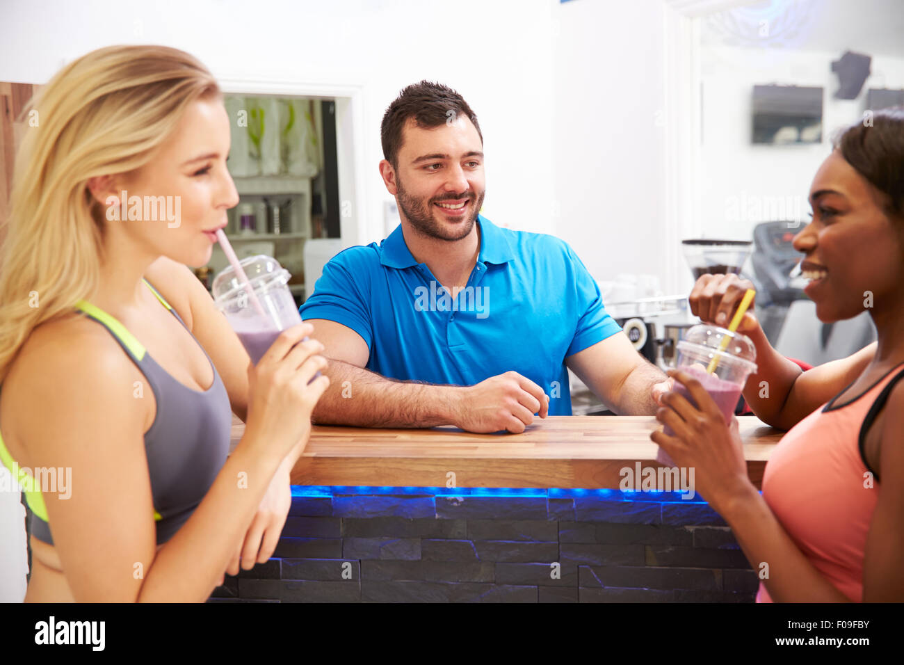 People drinking protein shakes at the fitness bar in a gym Stock Photo