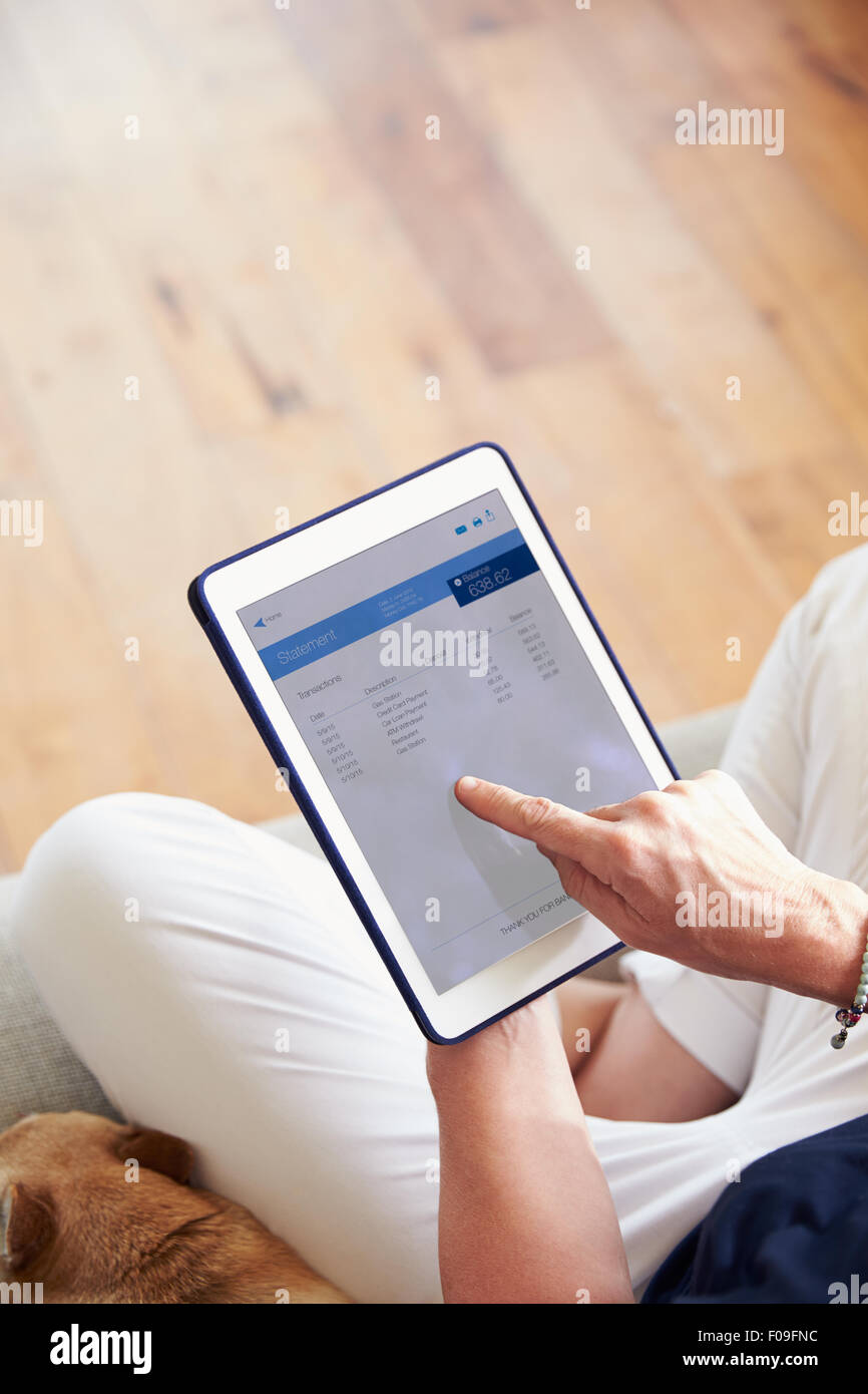 Woman Looking At Banking App On Digital Tablet Stock Photo