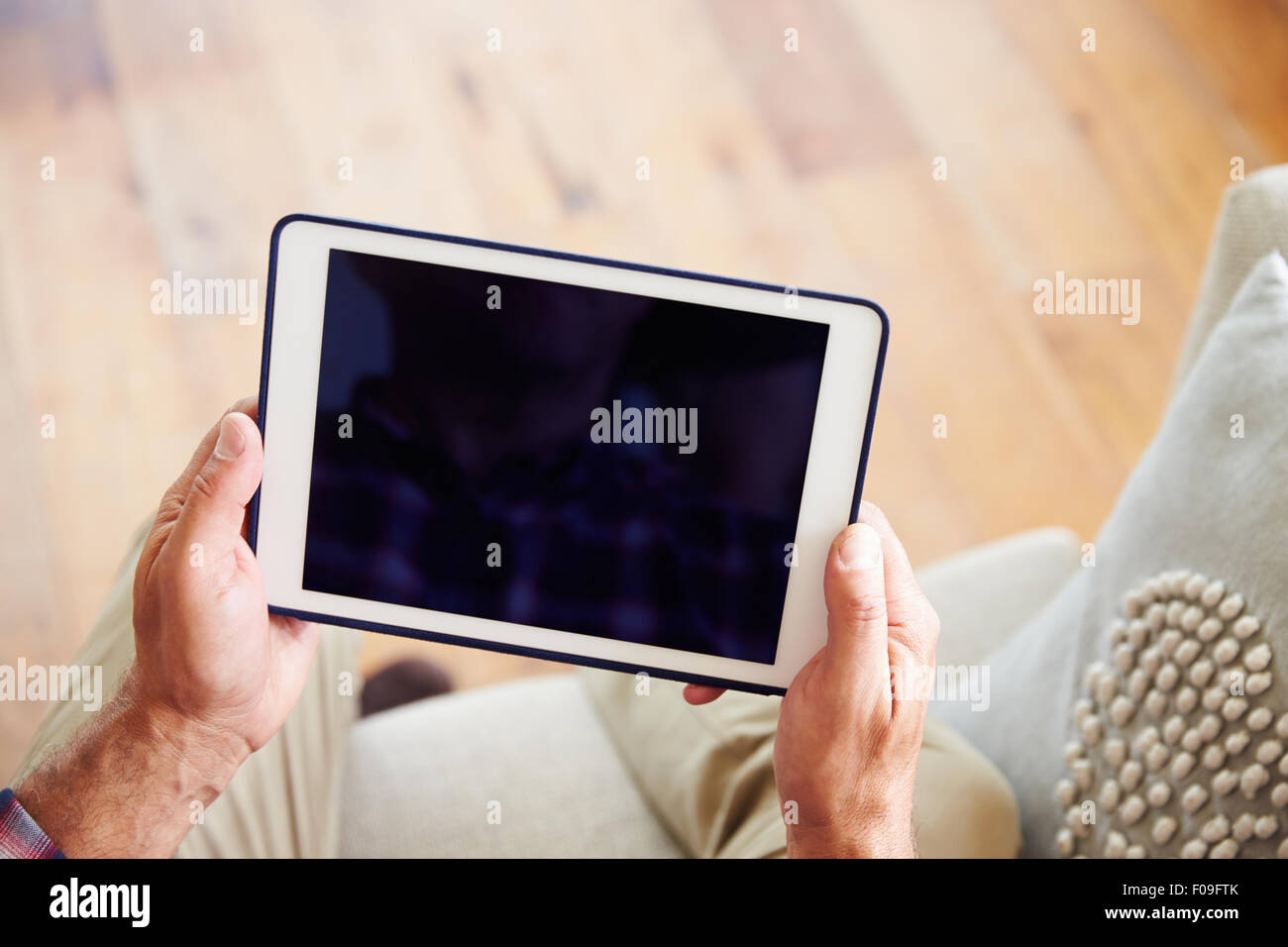 Close Up Of Man Using Digital Tablet At Home Stock Photo