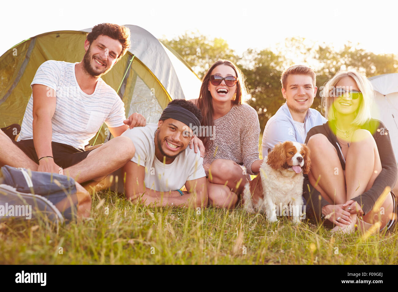 Group Of Friends Relaxing Outside Tents On Camping Holiday Stock Photo
