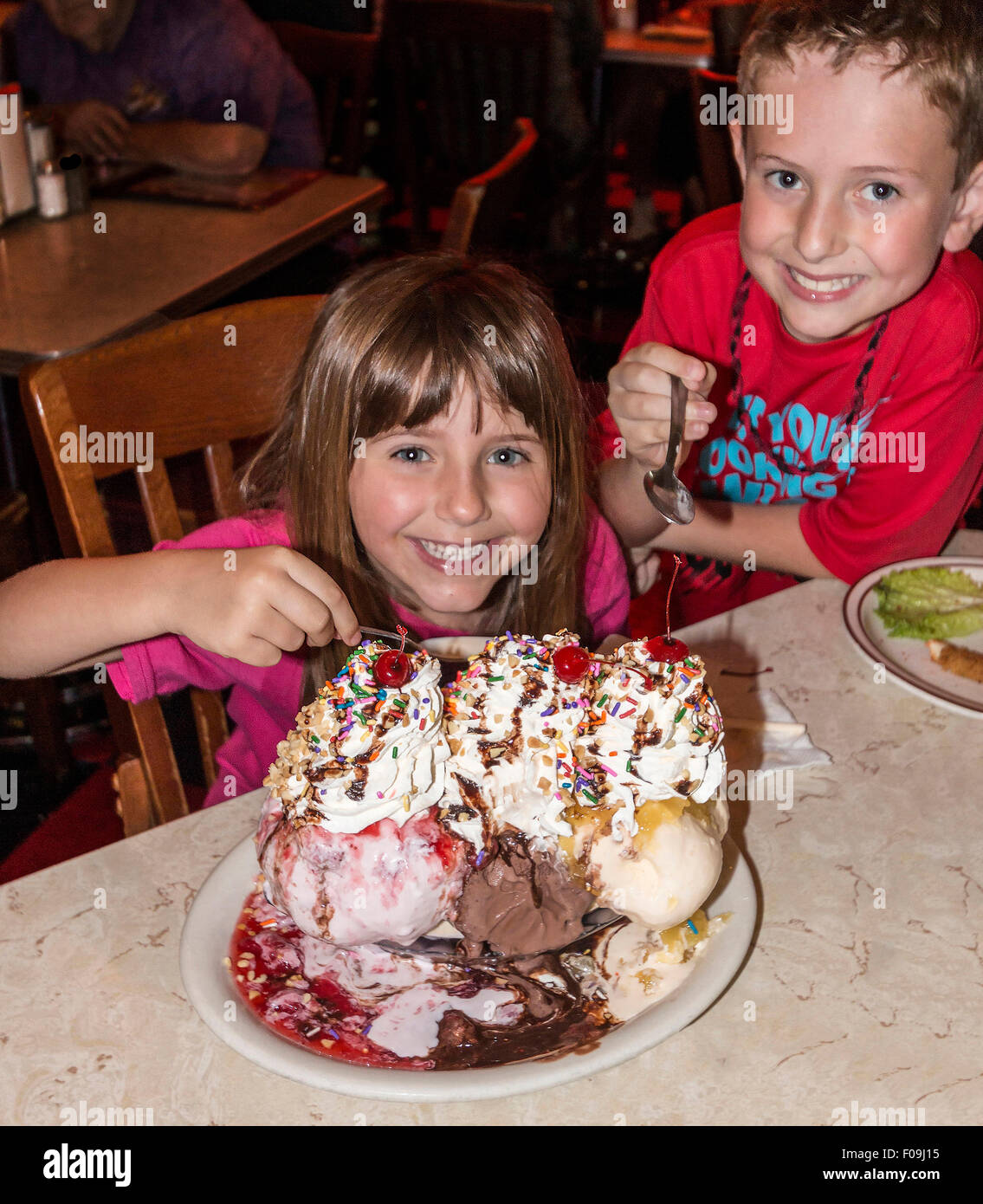 Boy and girl enjoy one of the infamous HUGE ice cream sundaes at Mel's Hard Luck Diner, a 1950s style cafe in Branson, MO. Stock Photo