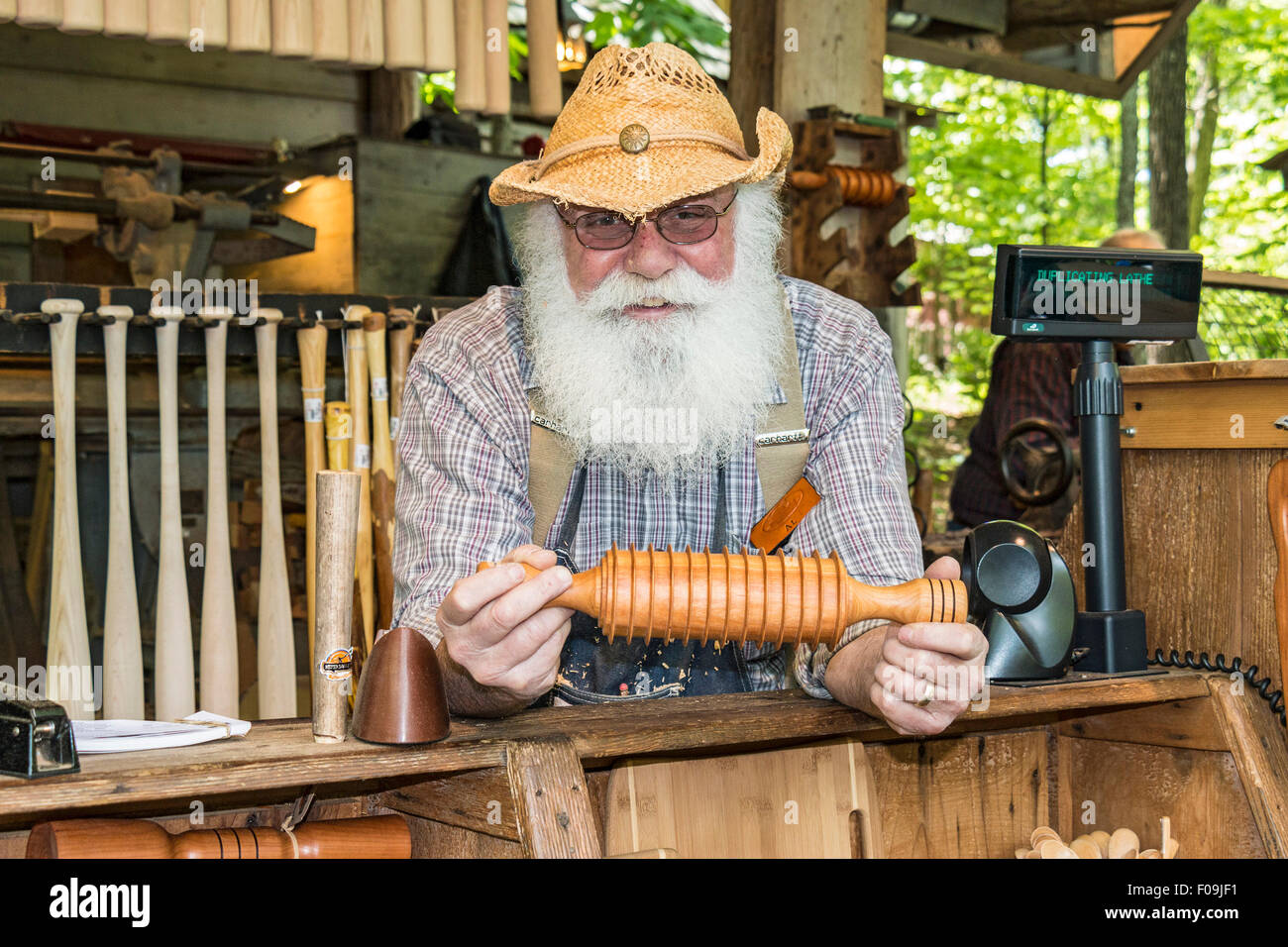 One of several wood carvers at Silver Dollar City, an 1880s theme amusement park near Branson, MO. Stock Photo