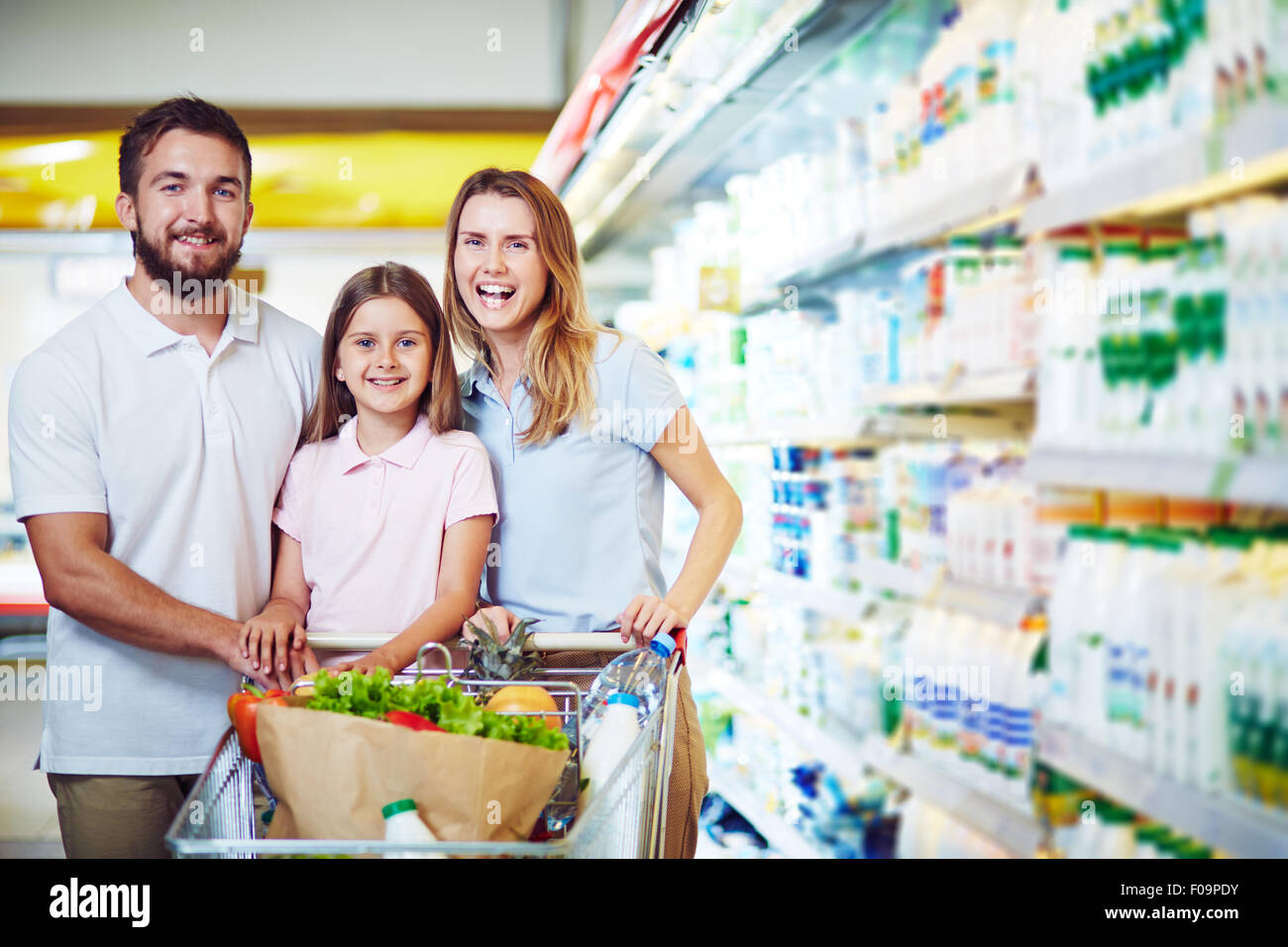 Cheerful family with shopping cart visiting supermarket Stock Photo Alamy