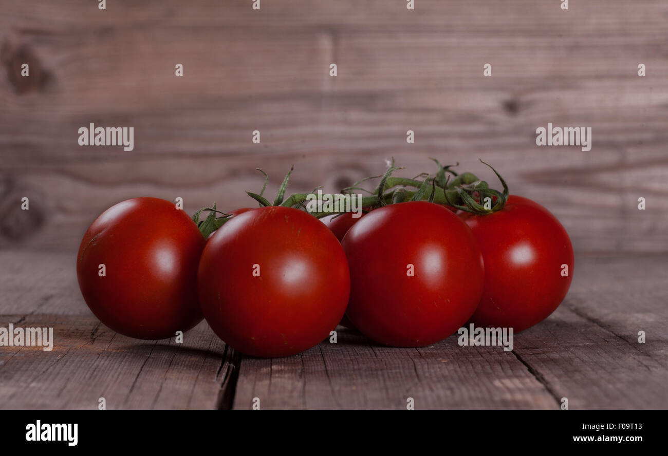red Tomatos on wooden table Stock Photo