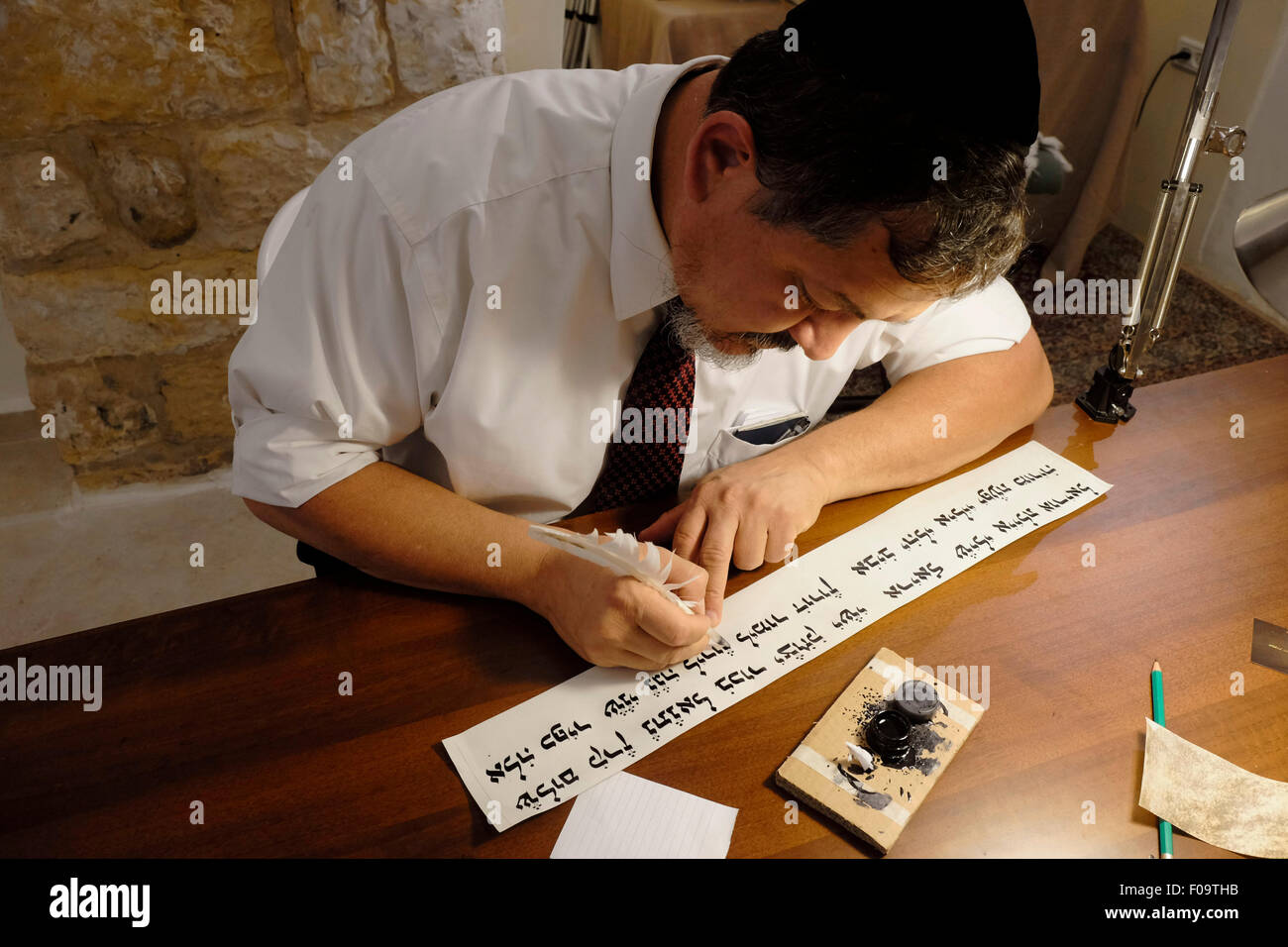 A religious Jewish 'Stam' calligrapher writing a Hebrew script on parchment in a Judaica workshop in the Jewish Quarter Old city East Jerusalem Israel Stock Photo
